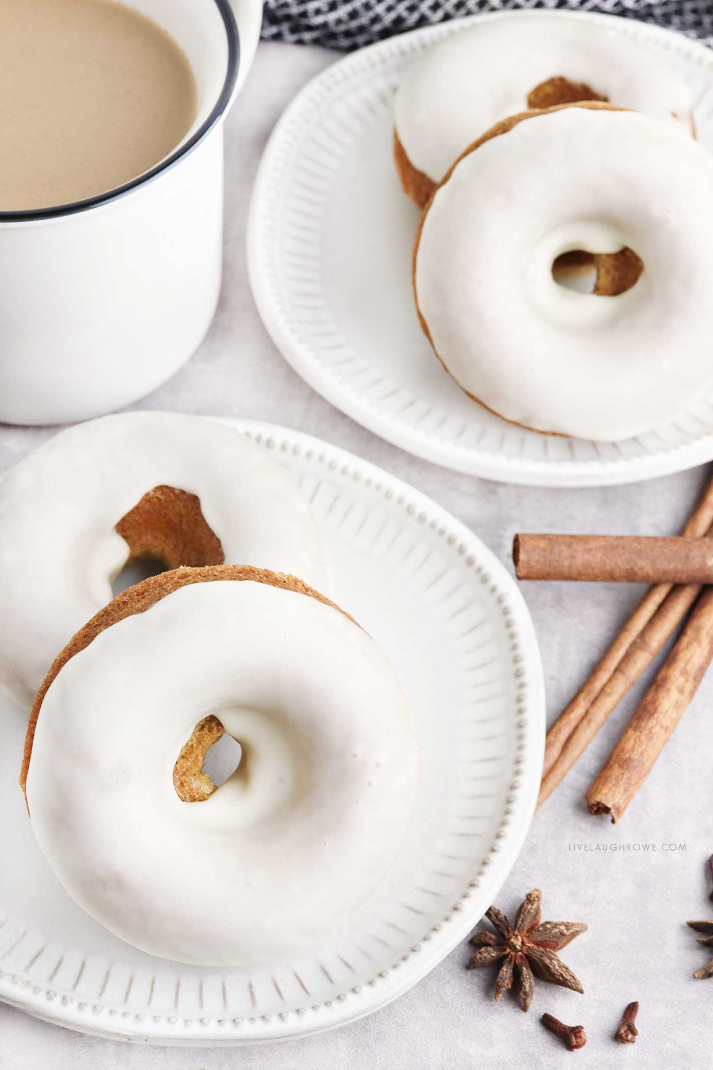 donuts pictured on white plates with spices surrounding and a cup of coffee pictured