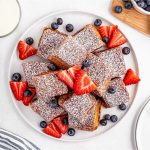 Golden brown Hawaiian Roll French Toast bites dusted with powdered sugar and served with maple syrup.