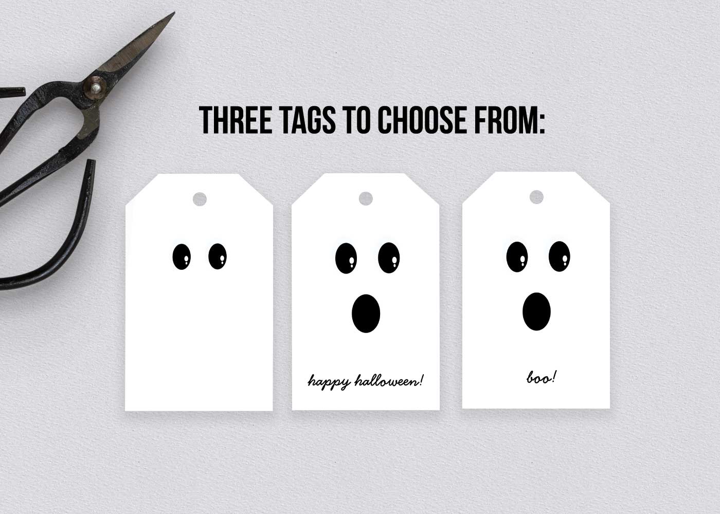 Three finished Halloween tags with cheerful ghost faces next to black scissors