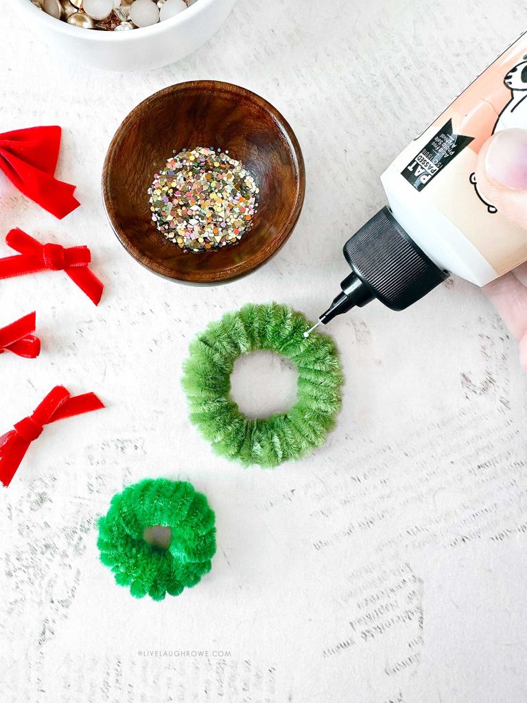 Decorating the mini pipe cleaner wreath with pearls and sequins.