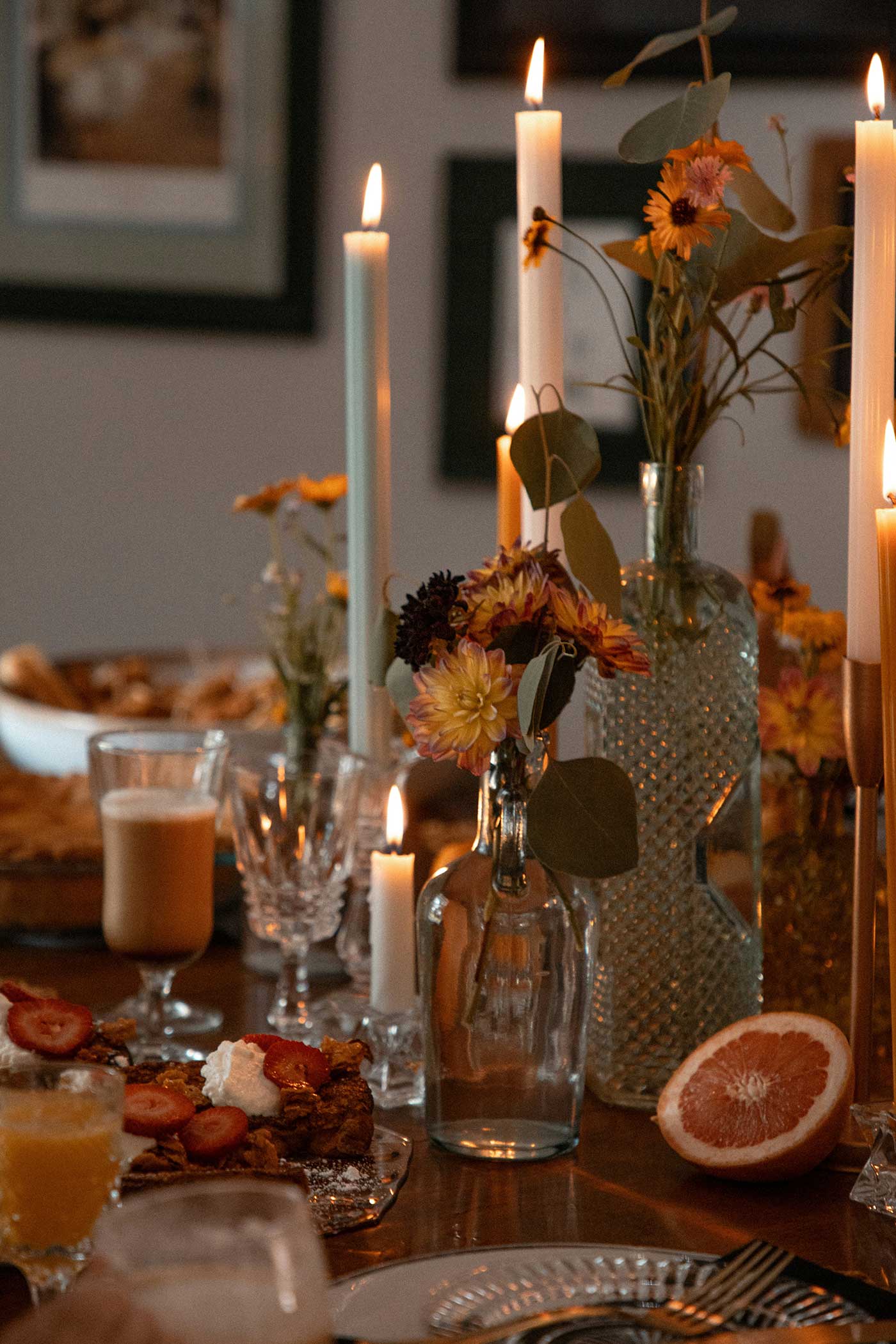 A beautifully styled holiday dinner table with flowers, candles, and seasonal food, creating a warm and inviting Thanksgiving atmosphere.