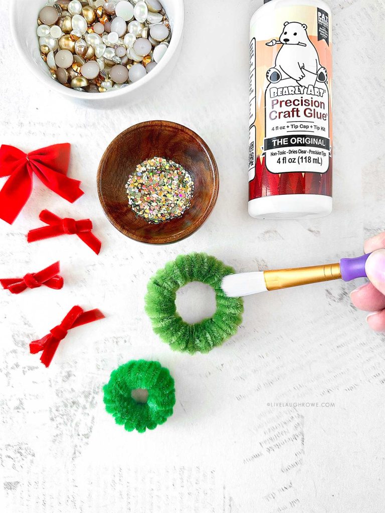 Decorating the mini pipe cleaner wreath with pearls and sequins.