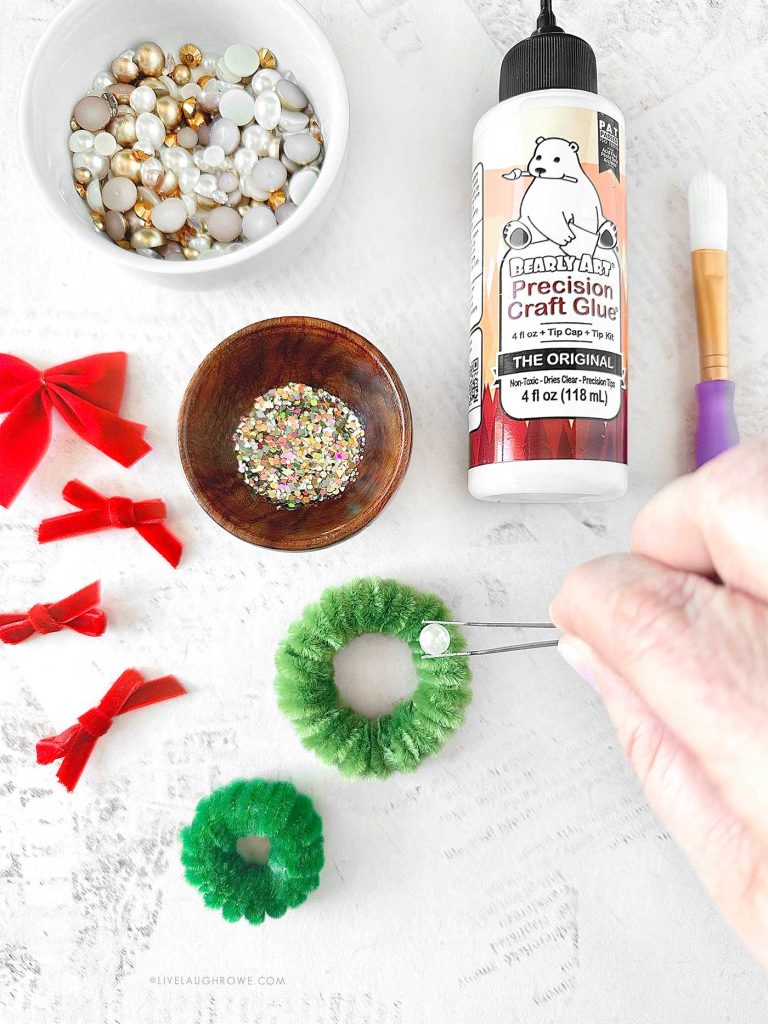 Decorating the mini pipe cleaner wreath with pearls and sequins.