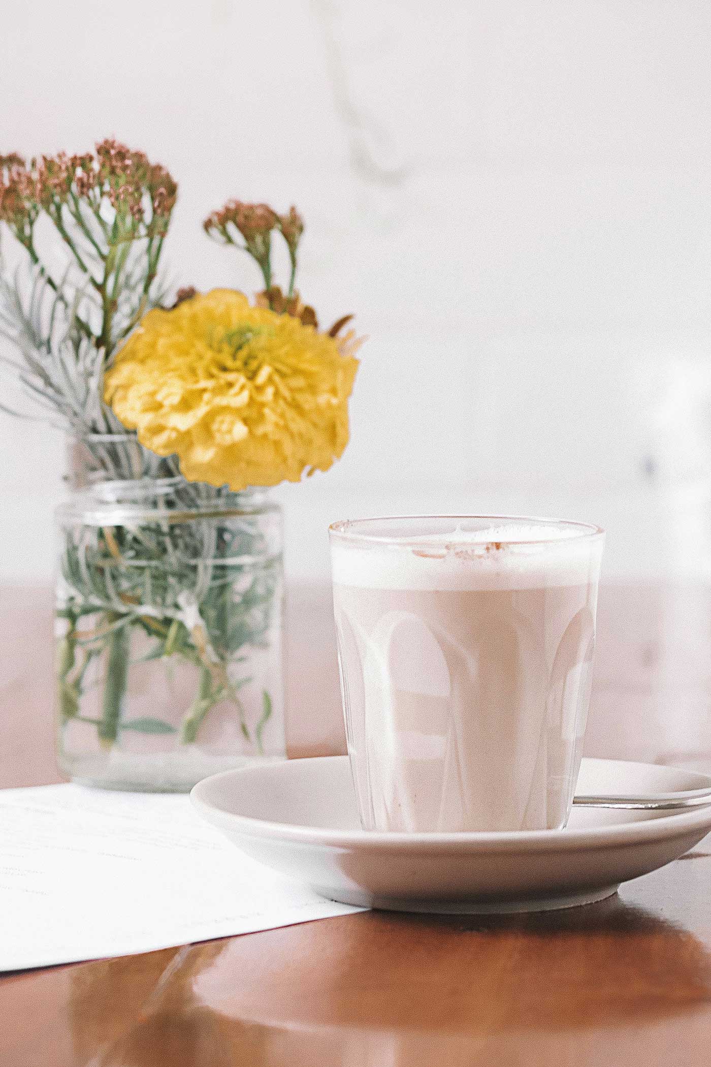 A refreshing iced chai latte in a clear glass with ice cubes and a straw — the perfect cool twist on classic chai flavor.