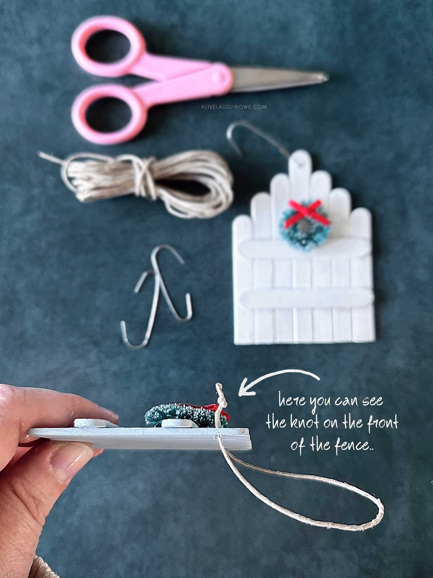 Close-up side view of a popsicle stick ornament showing where the twine knot is visible on the front.