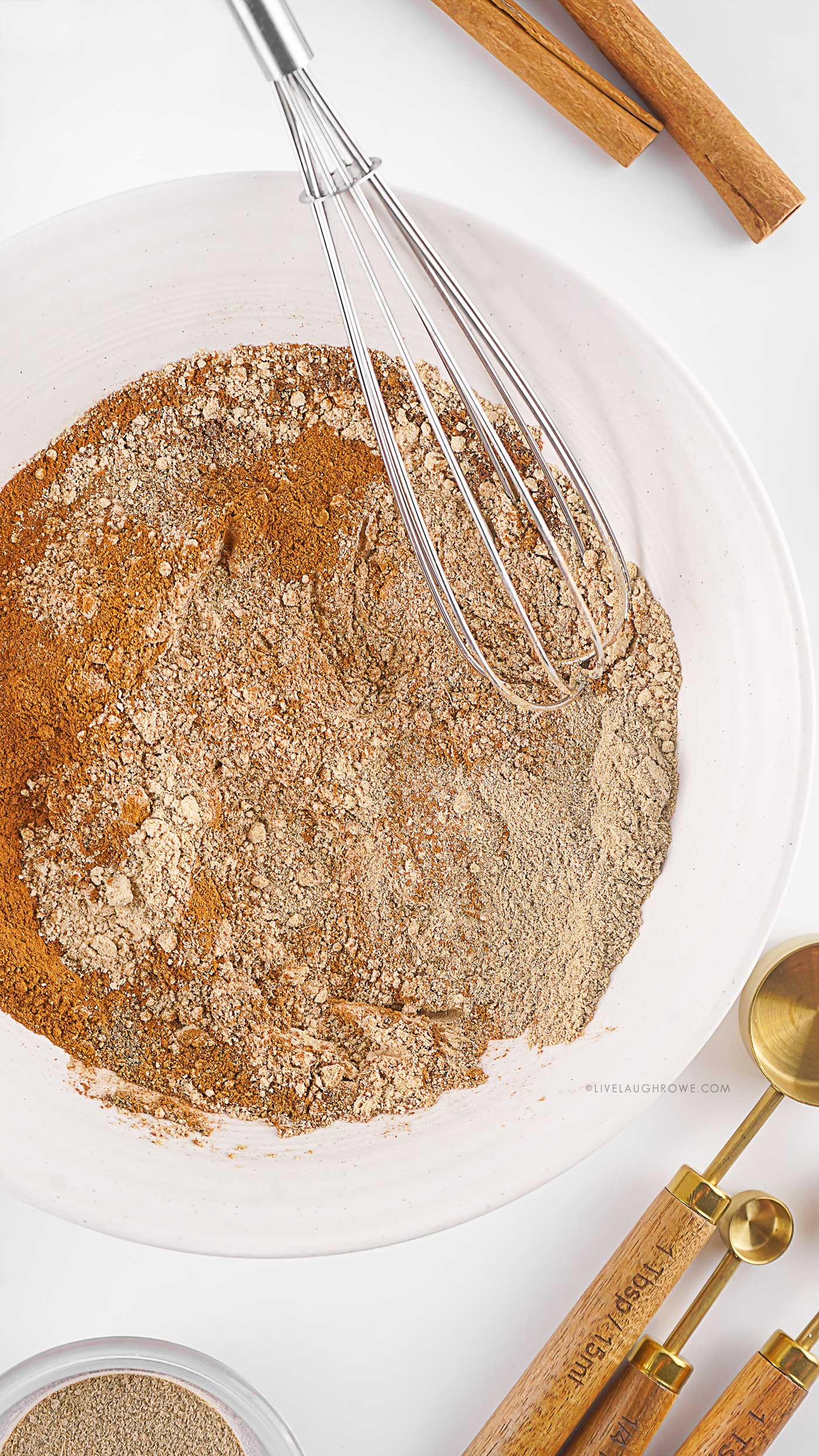 A cozy overhead view of spices being whisked together in a small white bowl.