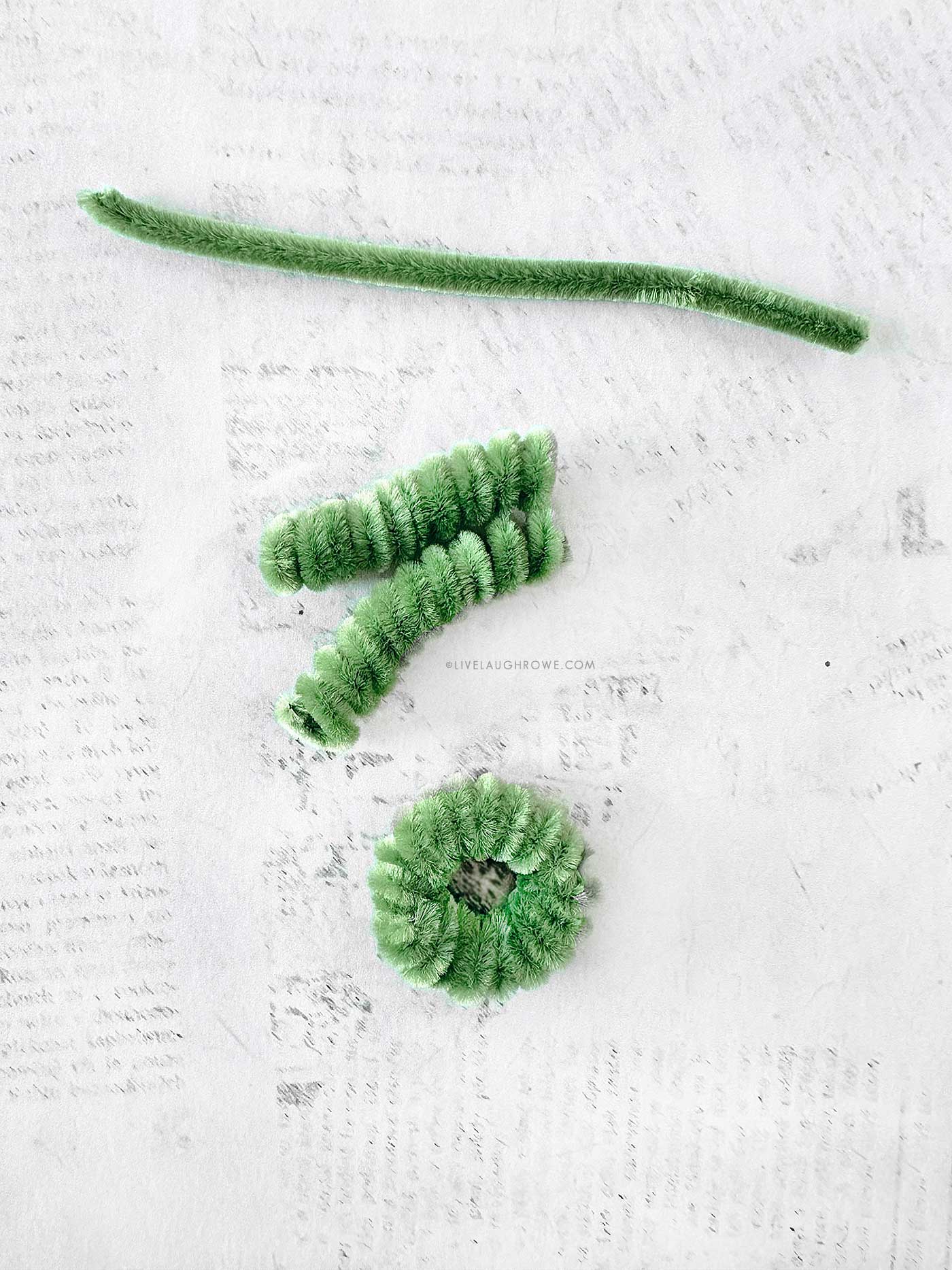 Tiny pipe cleaner wreath before embellishments, showing fluffy coils and secured ends.
