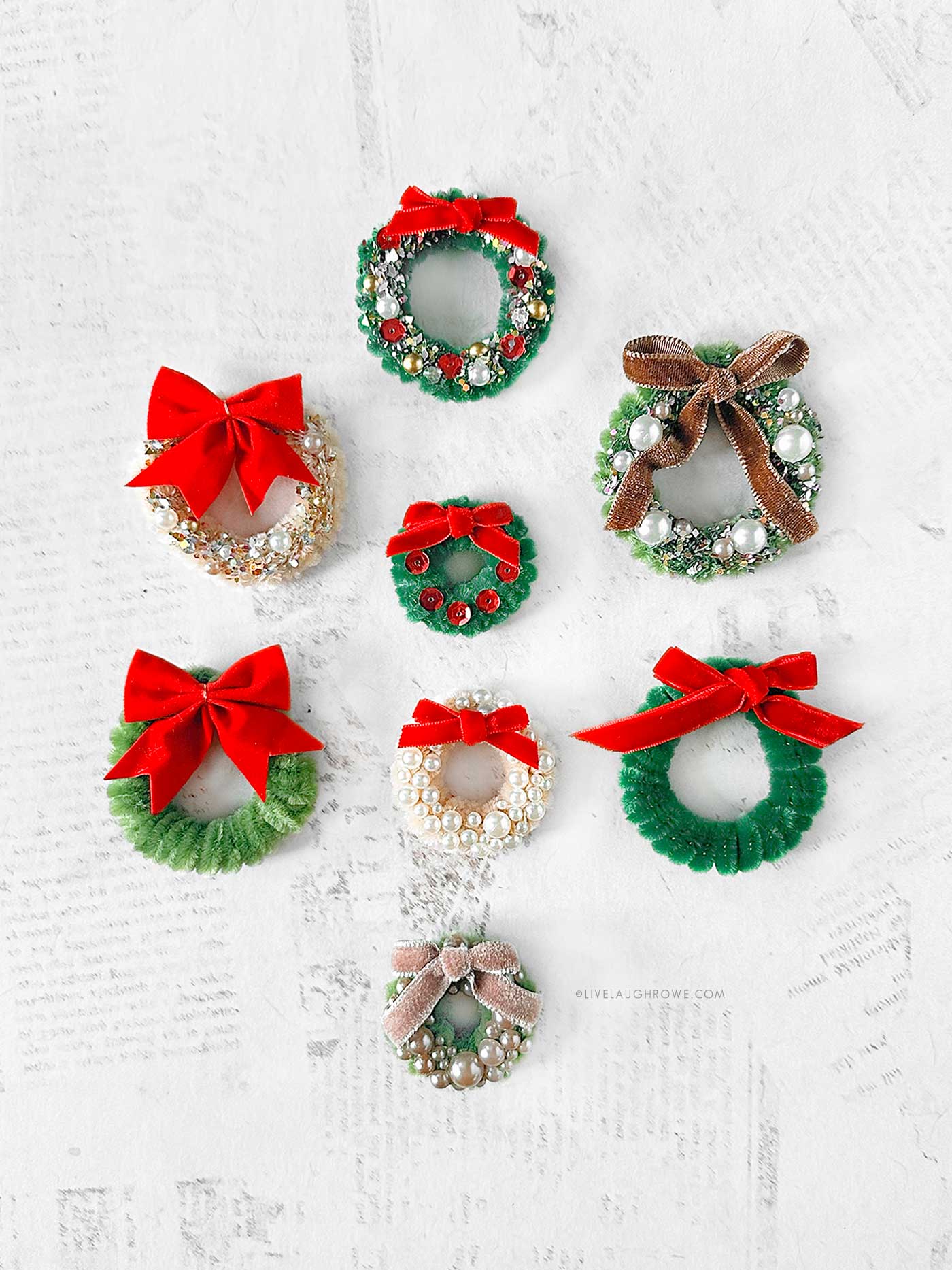 finished pipe cleaner wreaths decorated with bows, pearls, and sequins in festive holiday colors.