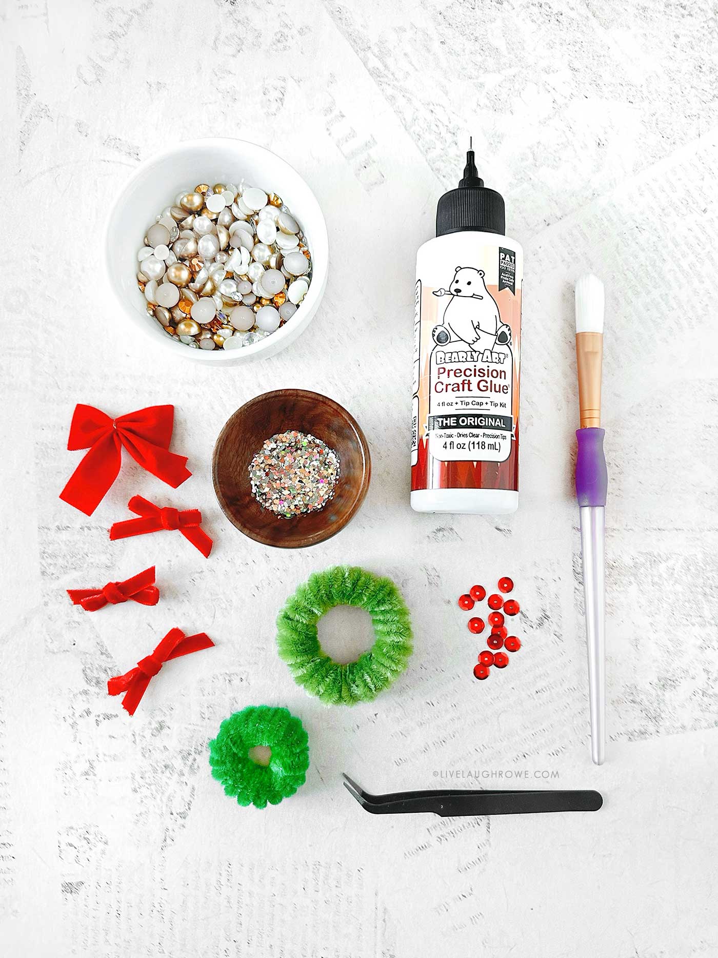 supplies that include flat pearls, bows, glue and glitter for decorating little wreaths