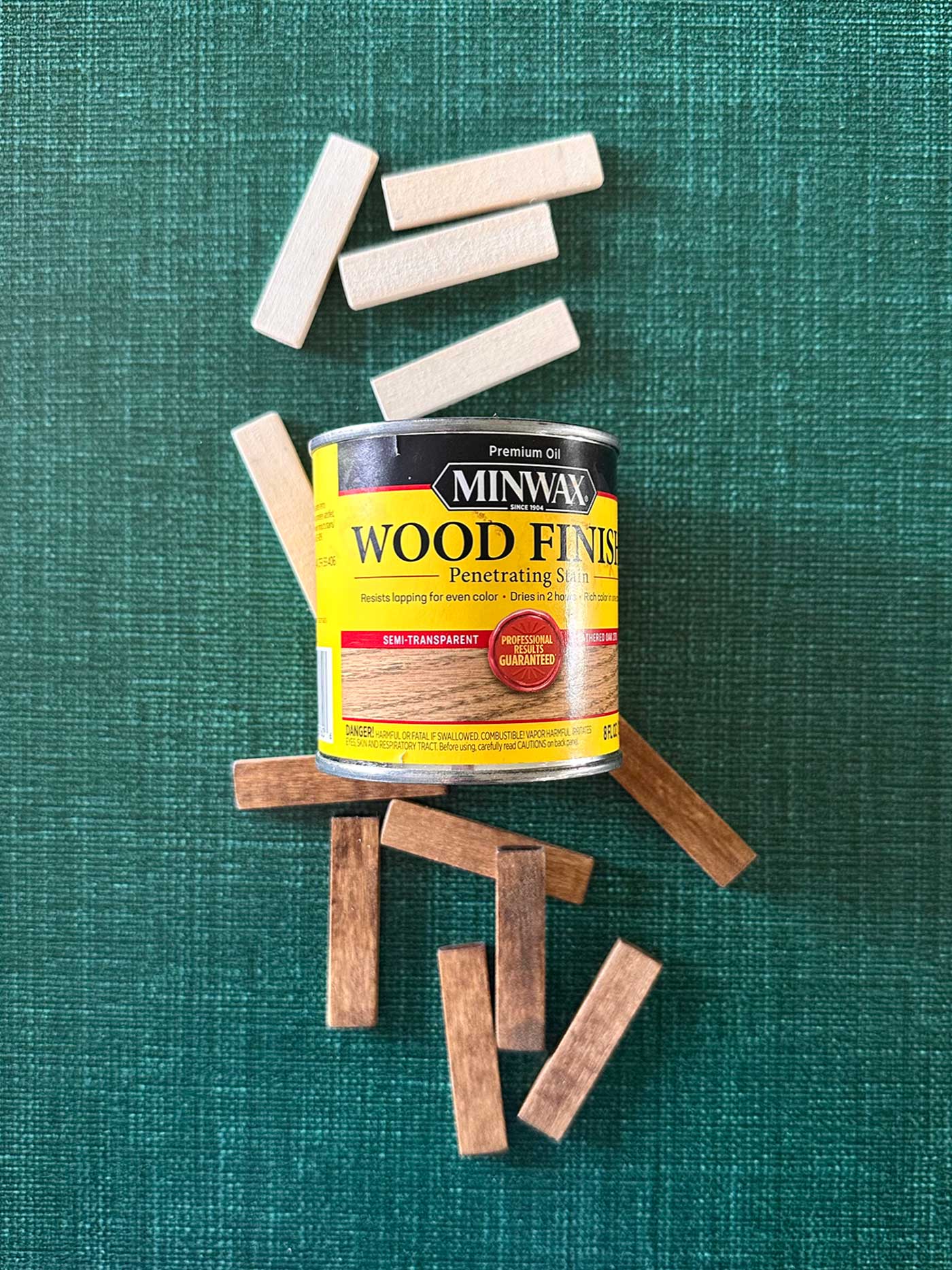 Wood strips before and after staining, used to create rustic mini poster hanger ornaments.