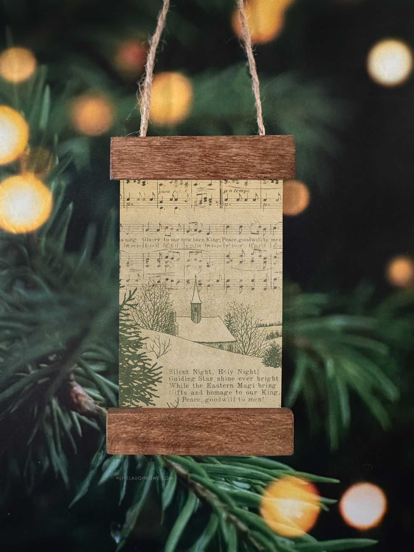 Vintage-inspired handmade Christmas ornament using sheet music artwork inside a mini poster hanger ornament with wooden trim.