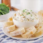 delicious party dip served with bread slices and fresh herbs.