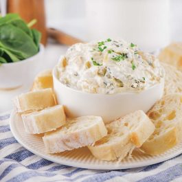 delicious party dip served with bread slices and fresh herbs.