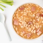 Bowl of homemade ham and bean soup with tender white beans and cubed ham