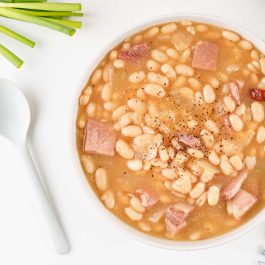 Bowl of homemade ham and bean soup with tender white beans and cubed ham