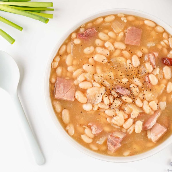 Bowl of homemade ham and bean soup with tender white beans and cubed ham