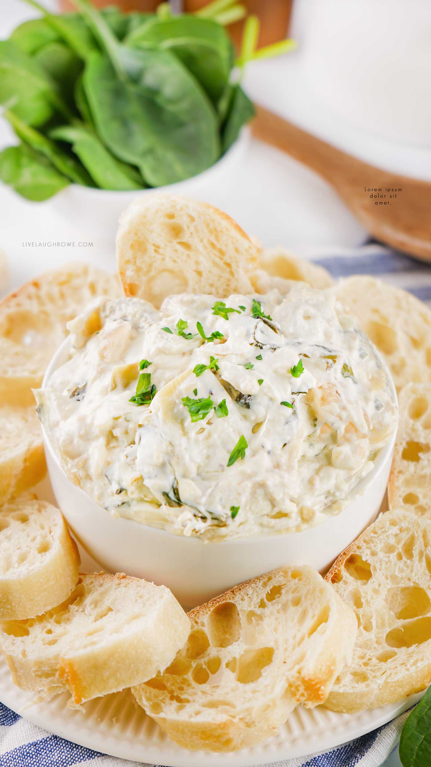 Spinach artichoke dip served in a bowl surrounded by sliced bread, perfect for entertaining.