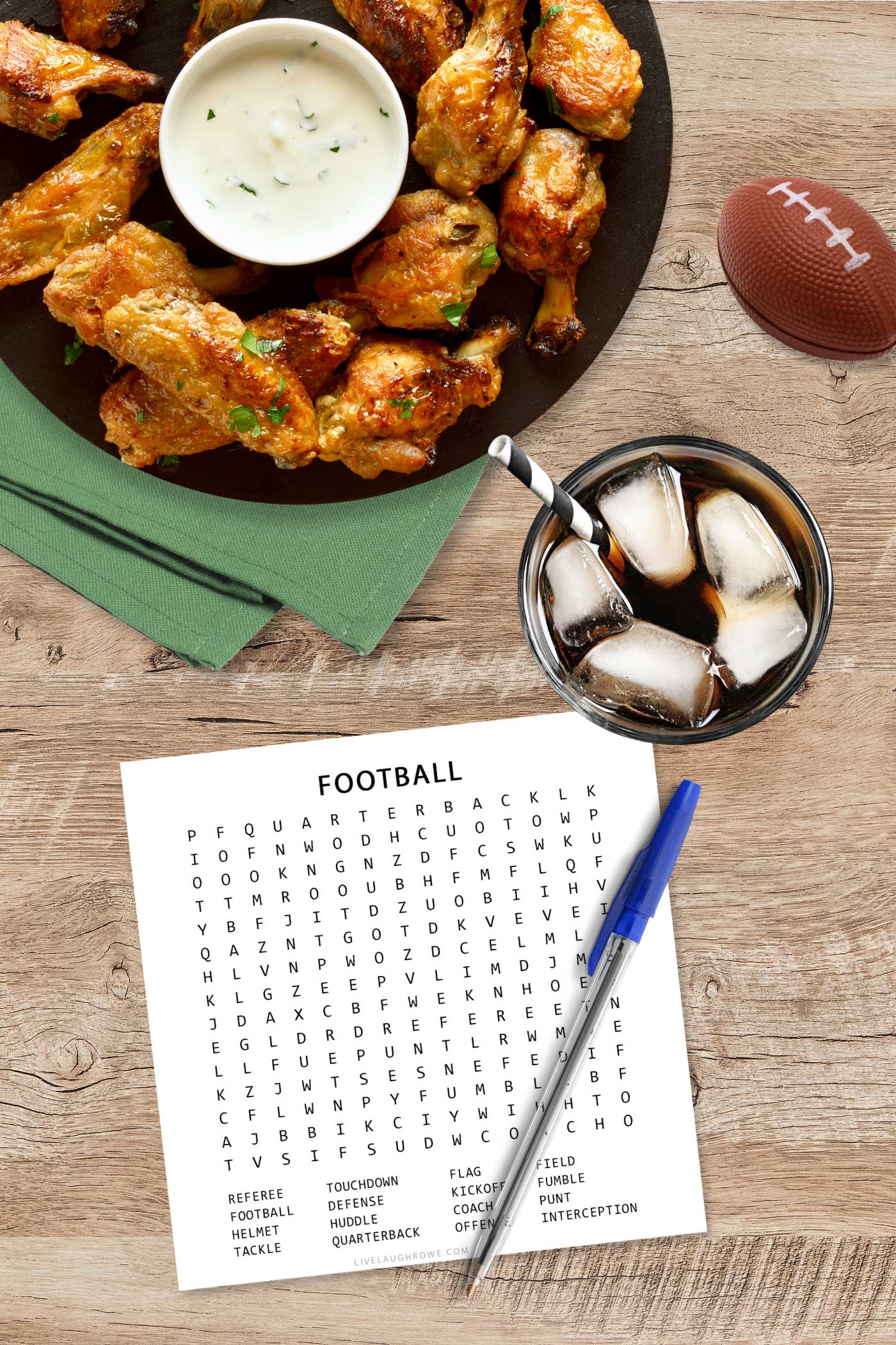 Football Word Search printable on a table with pen and snacks for Super Bowl Sunday