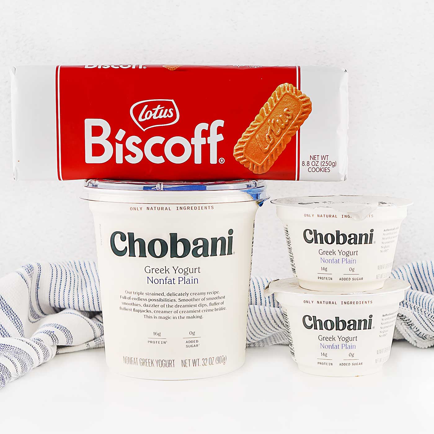 Greek yogurt containers and Biscoff cookies displayed together for making viral 2 ingredient Japanese cheesecake.