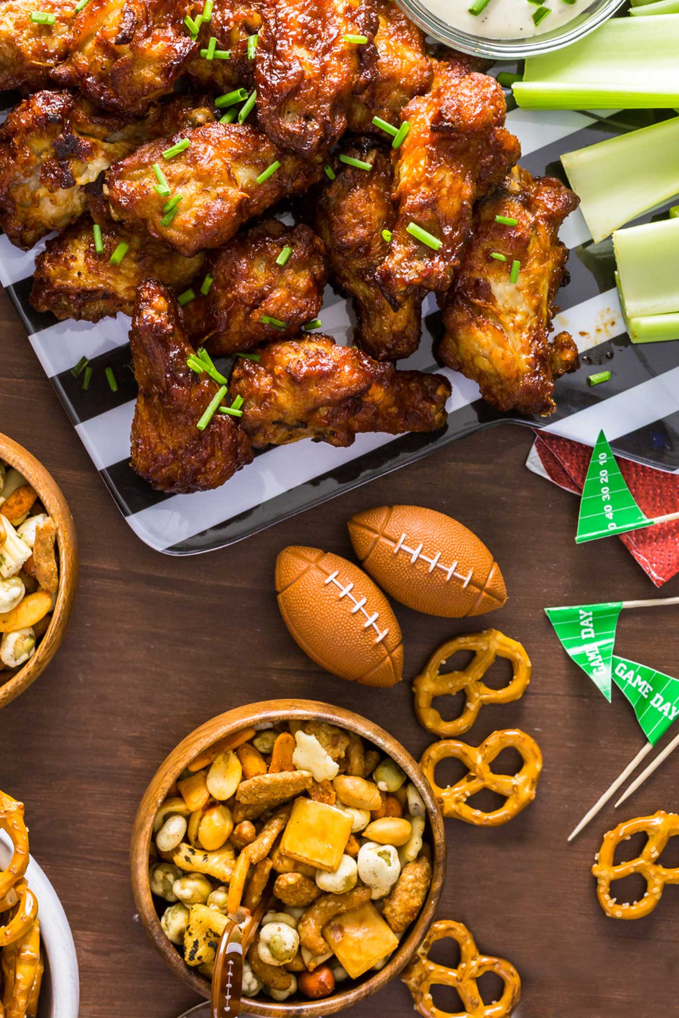 Super Bowl snack table with wings, pretzels, popcorn, and football decorations