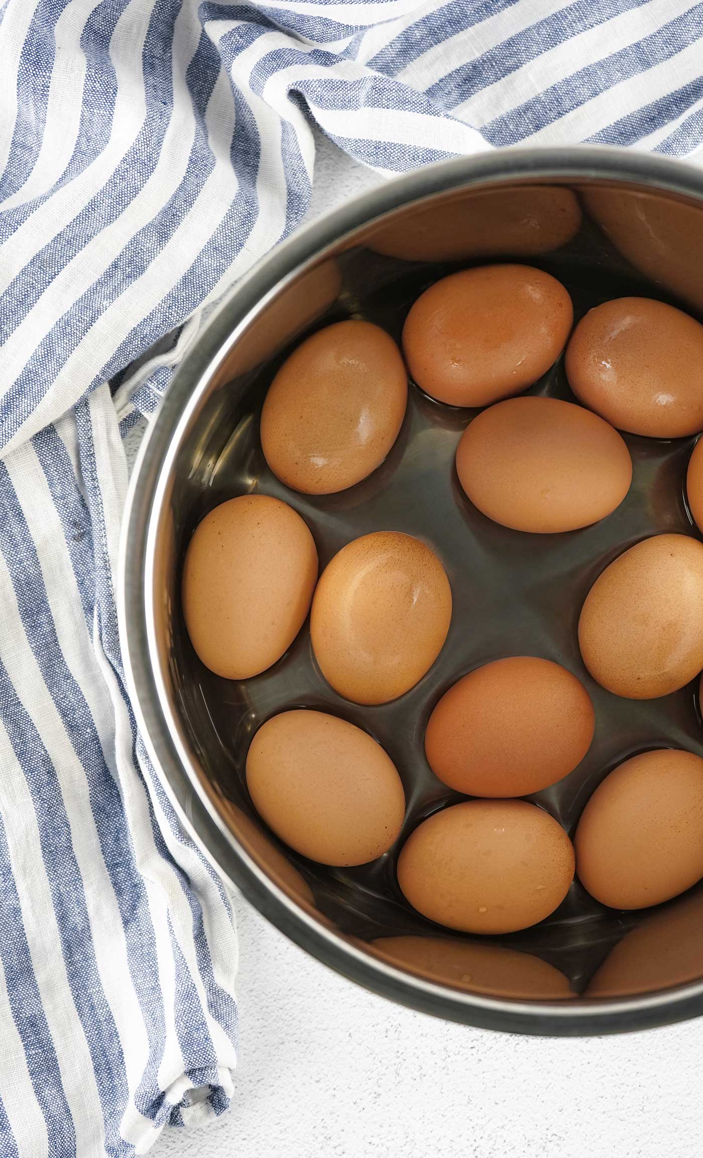 Whole eggs arranged inside an Instant Pot before pressure cooking