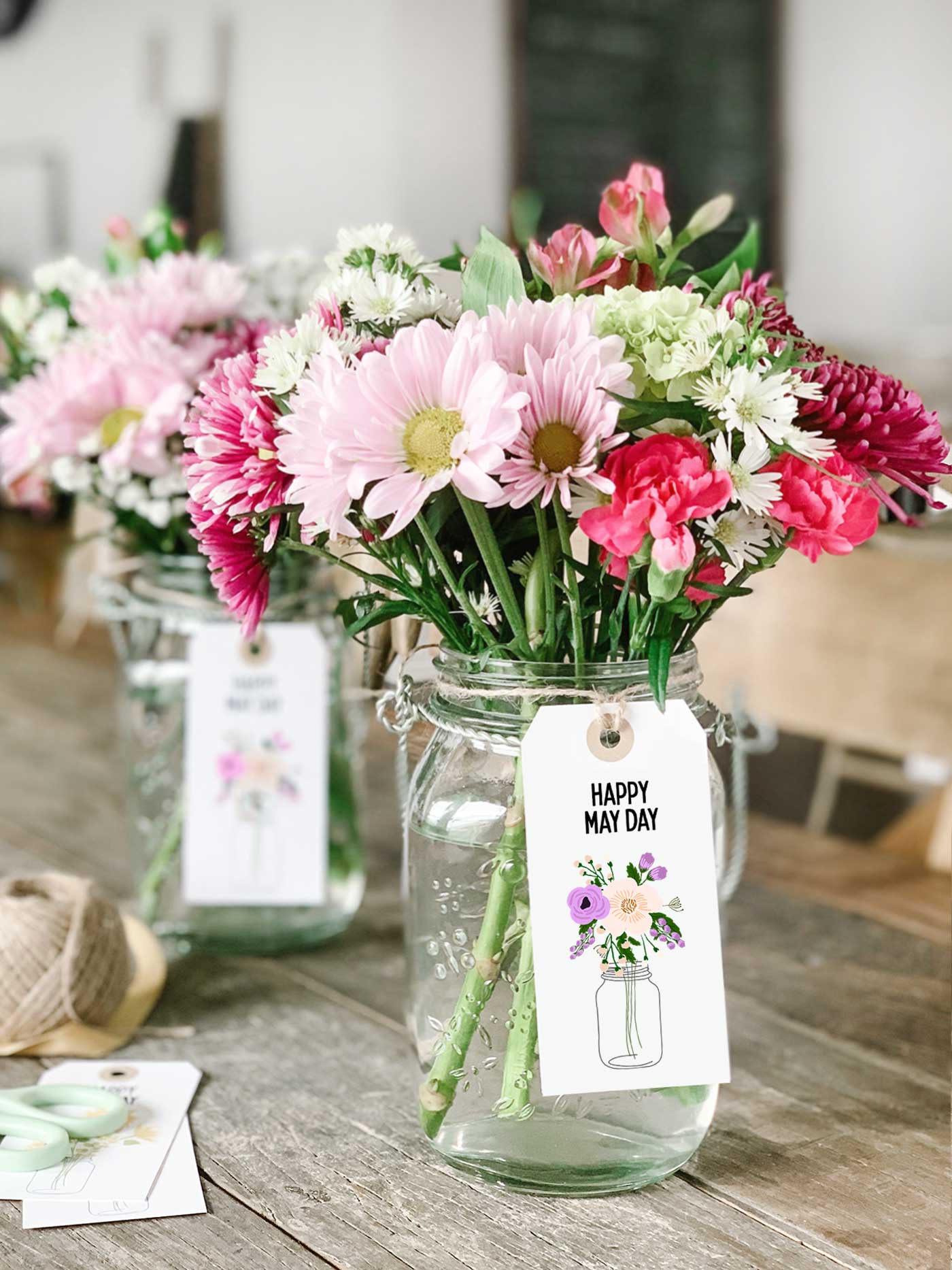 mason jar filled with pink and white flowers with a Happy May Day printable tag attached