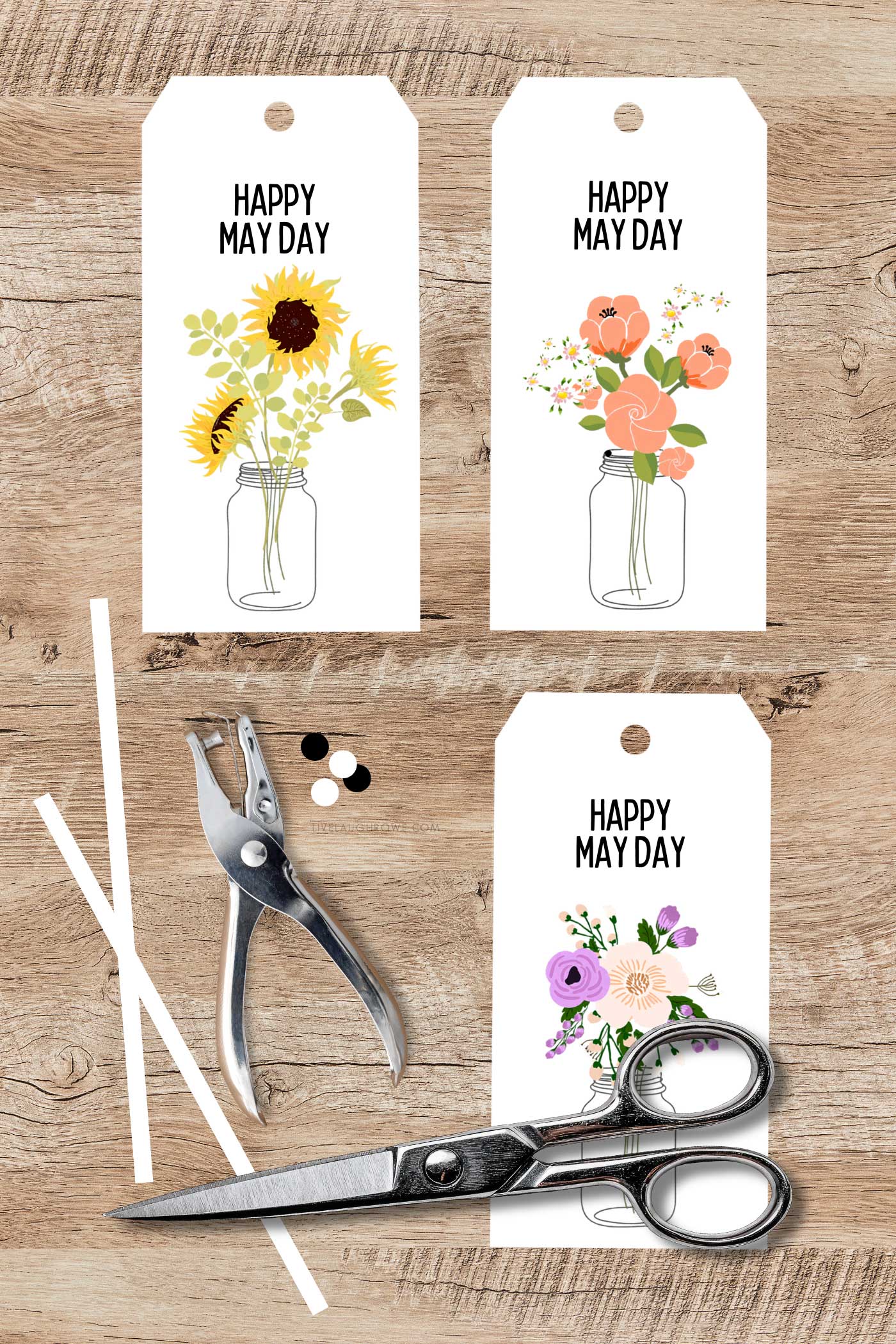 Happy May Day printable tags with scissors and hole punch on a wooden surface ready for a spring craft