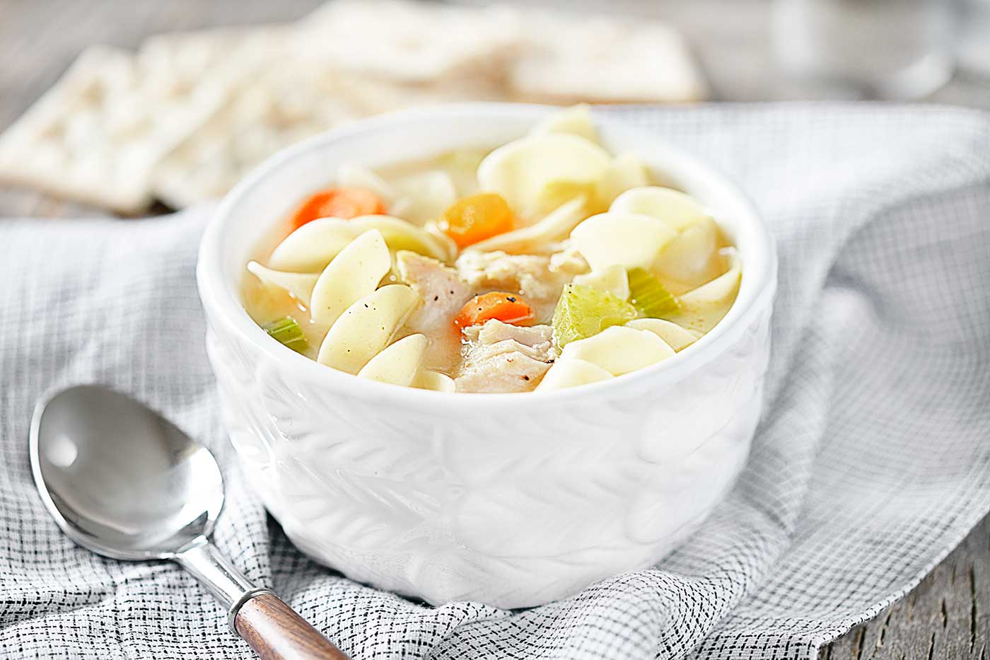 easy crockpot chicken noodle soup with carrots, celery, and noodles served in a white bowl