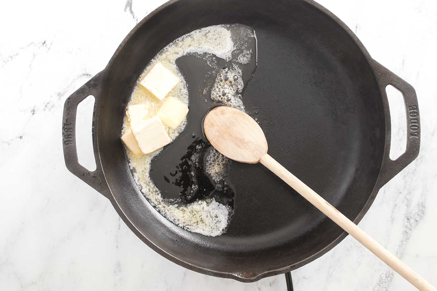 Butter and honey melting together in a skillet to start honey butter skillet corn