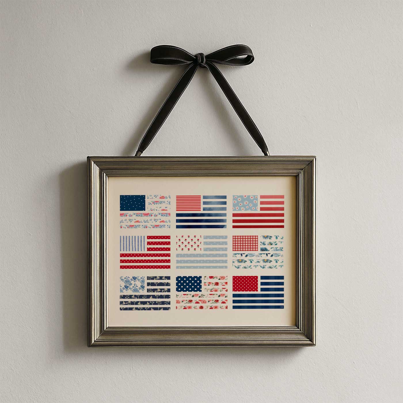 American flag wall art printable featuring nine floral and patterned flag designs displayed in a vintage gold frame hanging from a black ribbon.