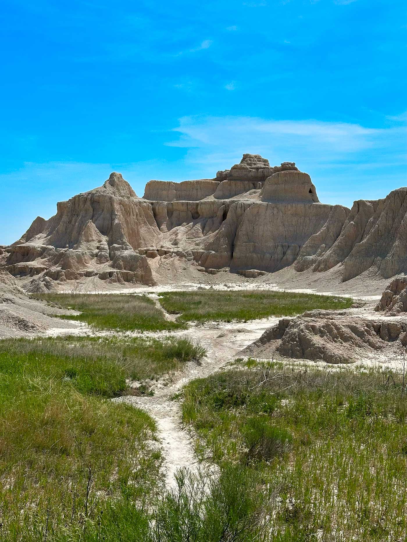 Rock formations rising above prairie grass in Badlands National Park.