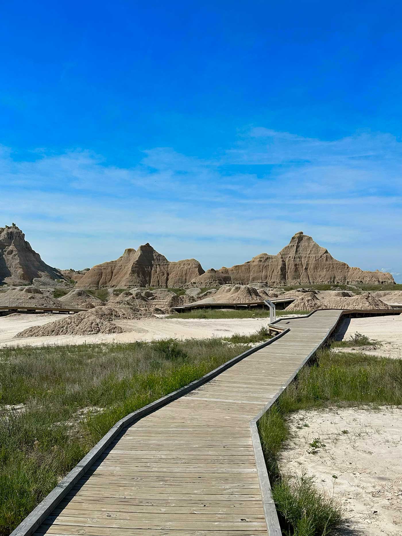Wooden boardwalk leading through the landscape of Badlands National Park.