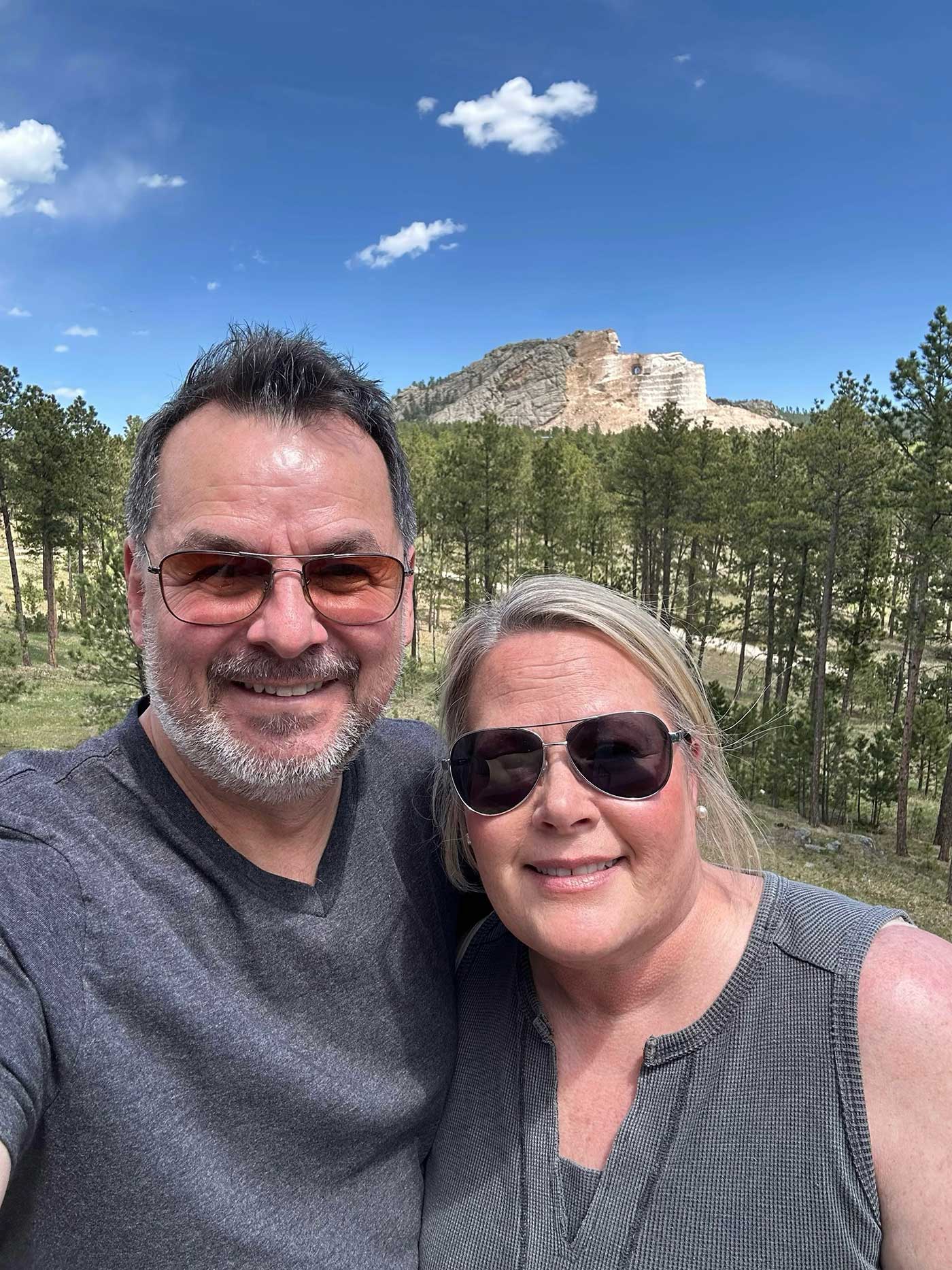 Couple posing for a photo with scenic Black Hills rock formations in the background.