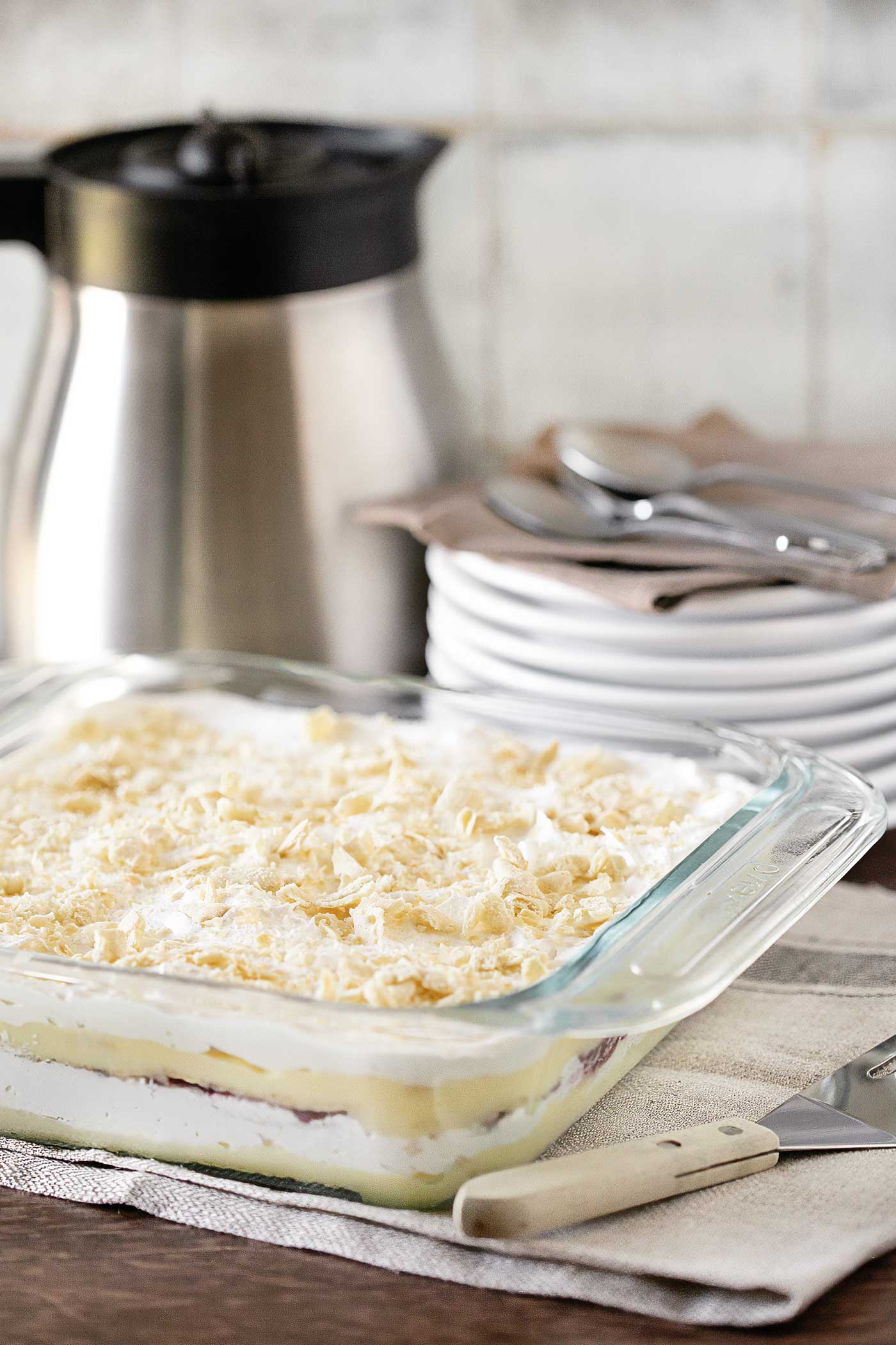 Homemade no-bake dessert in a glass baking dish topped with crushed cracker crumbs.