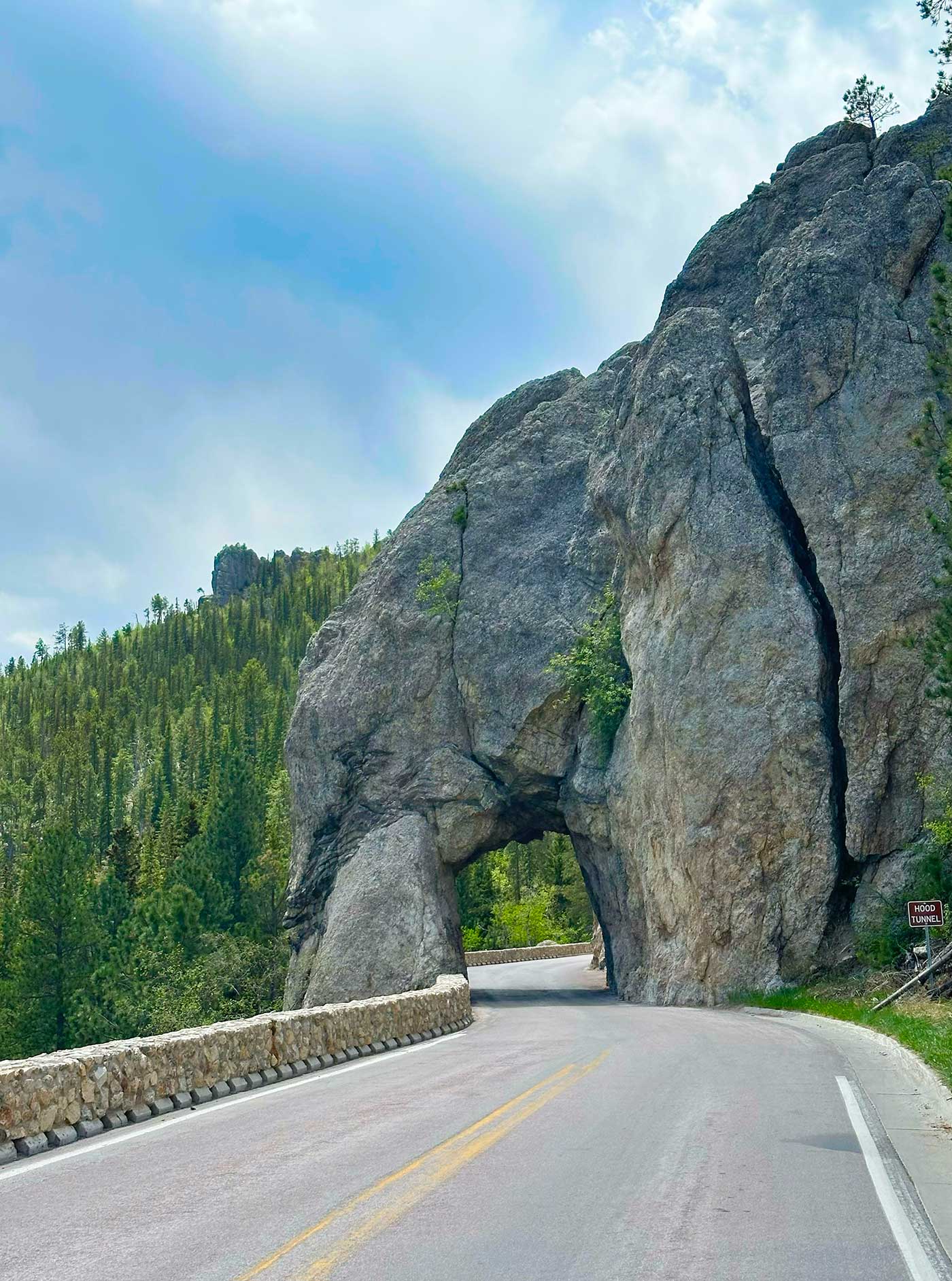 Vehicle roadway passing through the narrow Needles Eye Tunnel carved into granite rock.