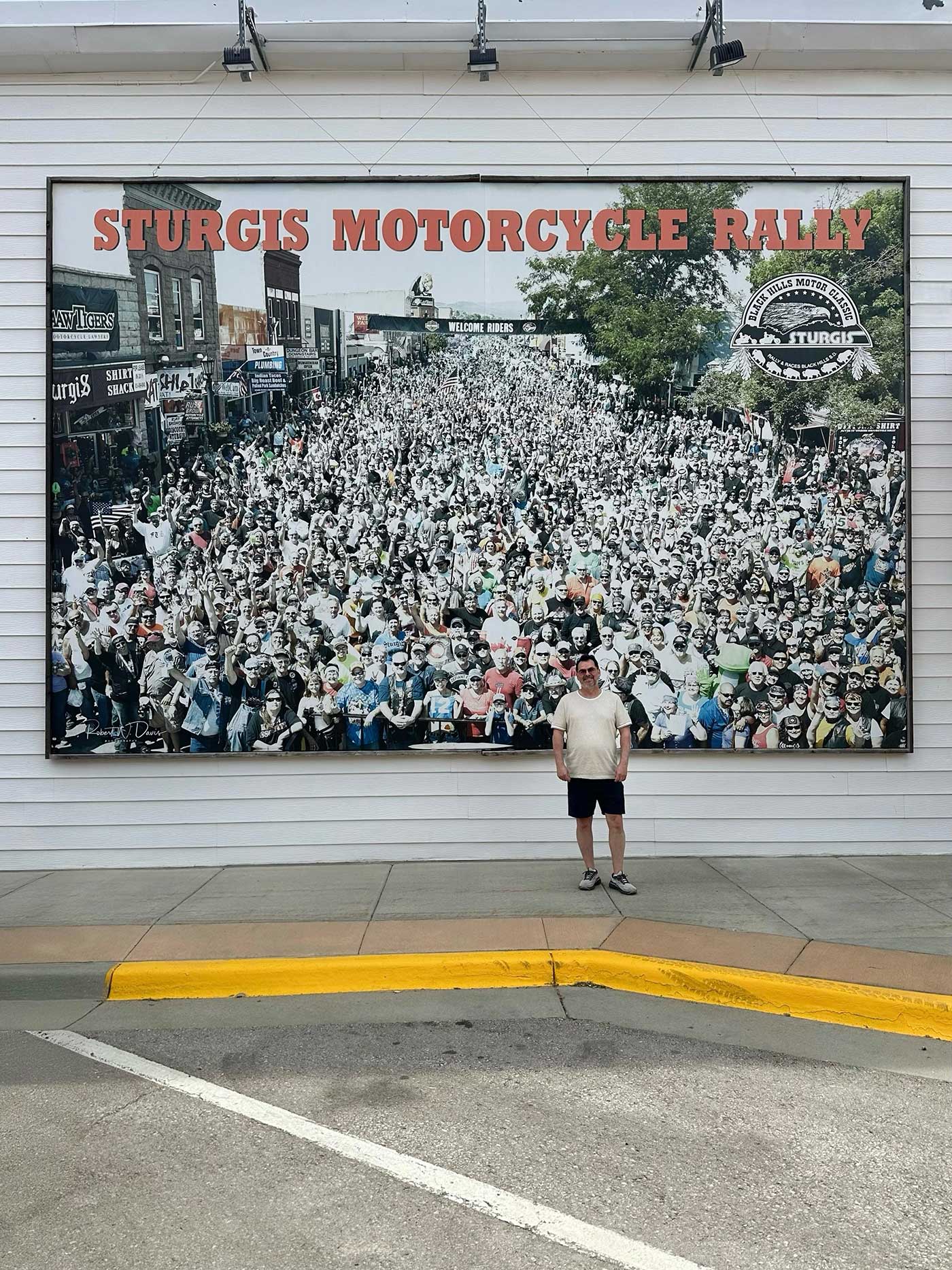 Large display showcasing the Sturgis Motorcycle Rally with a visitor standing in front.