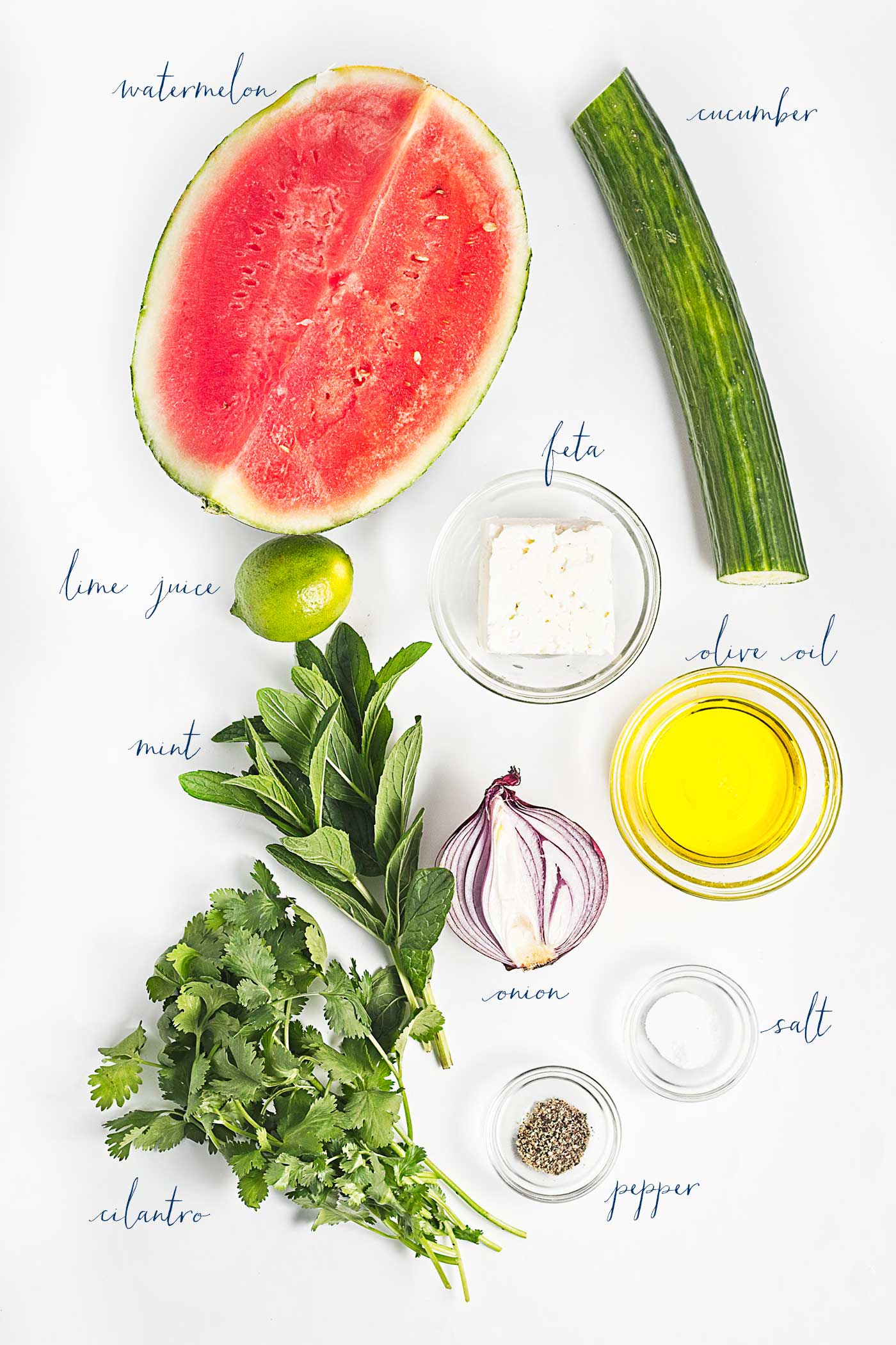 Ingredients for watermelon salad including watermelon, cucumber, feta, lime, red onion, mint, cilantro, olive oil, salt, and pepper.