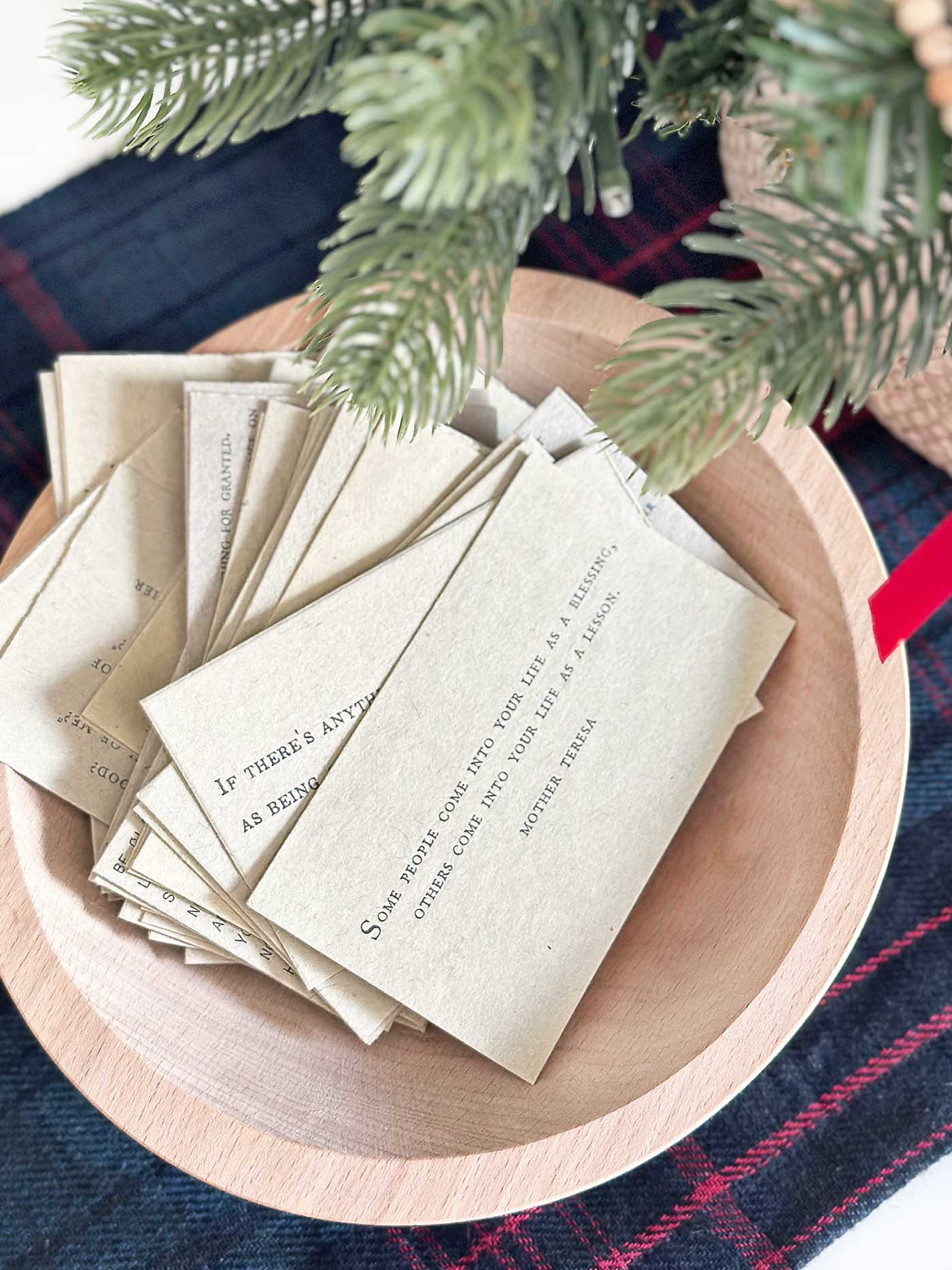 A wooden bowl filled with vintage-inspired quote cards ready for guests to choose.