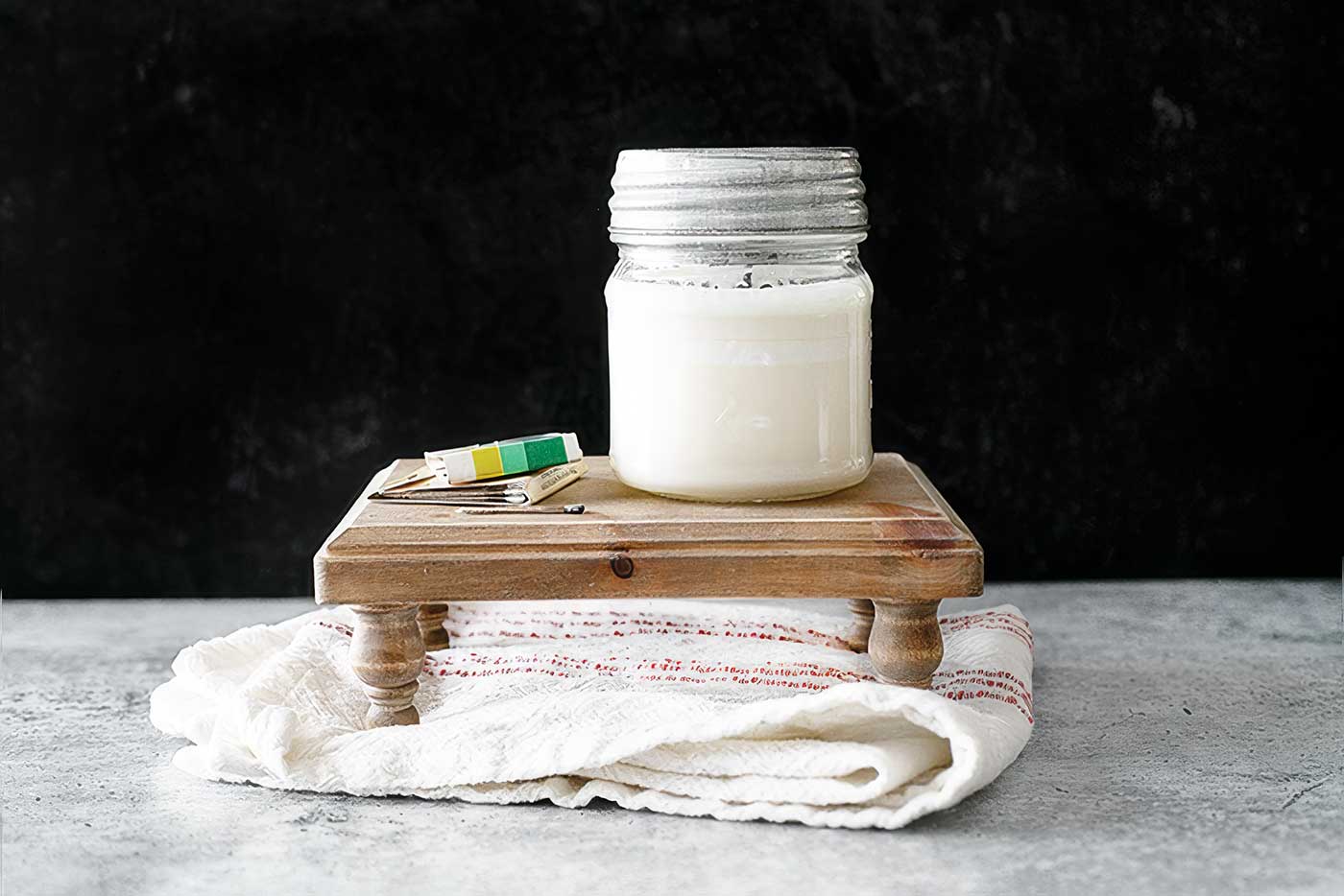 Small wooden display riser styled with a candle and matches on a folded cloth