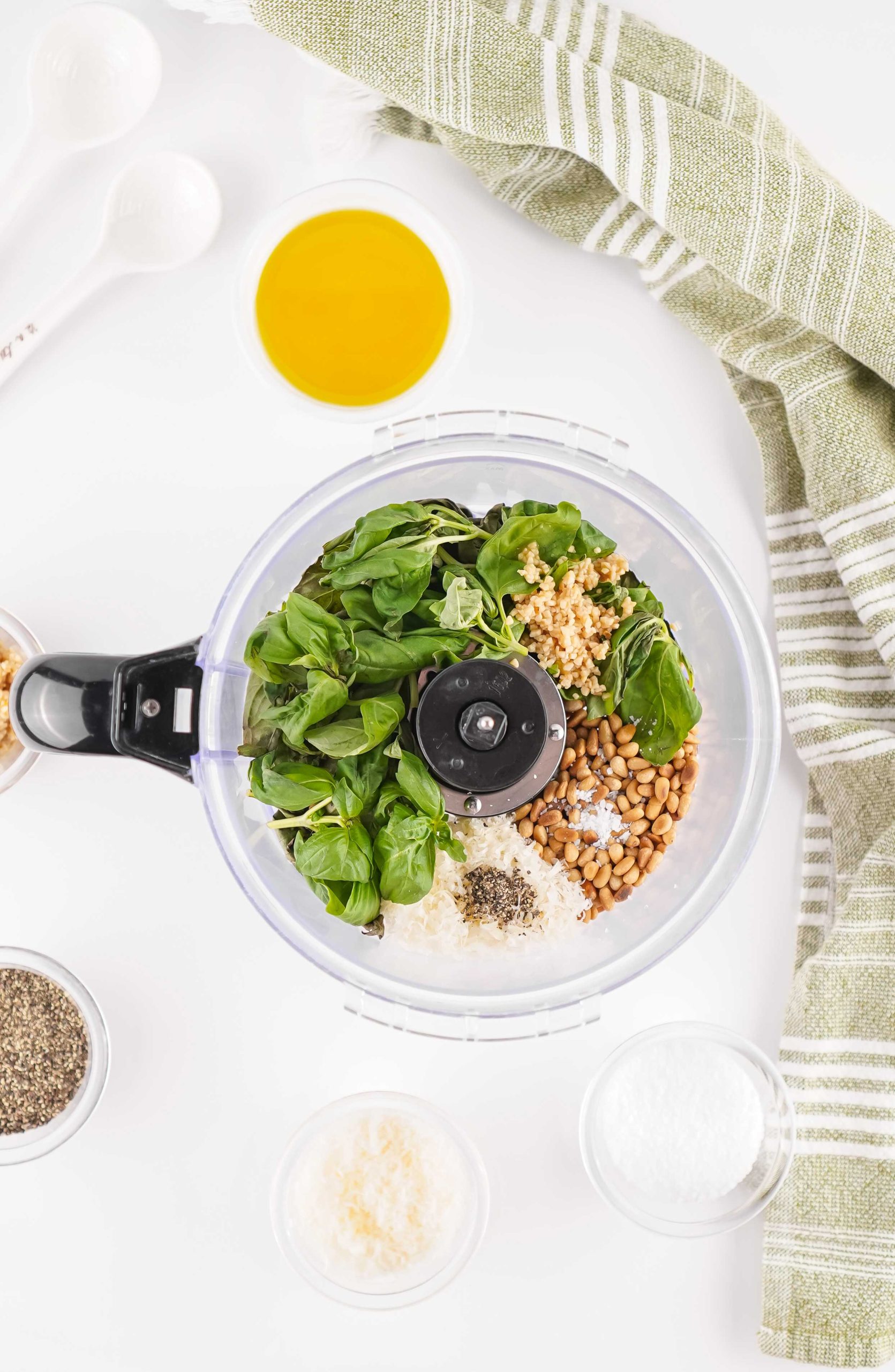 Fresh basil, toasted pine nuts, Parmesan, garlic, salt, and pepper in a food processor for homemade pesto.