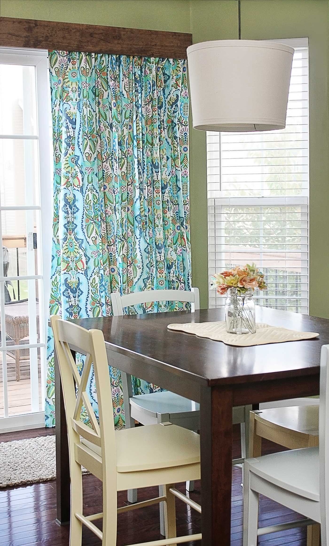 Rustic wood cornice box installed above colorful curtains in a dining room