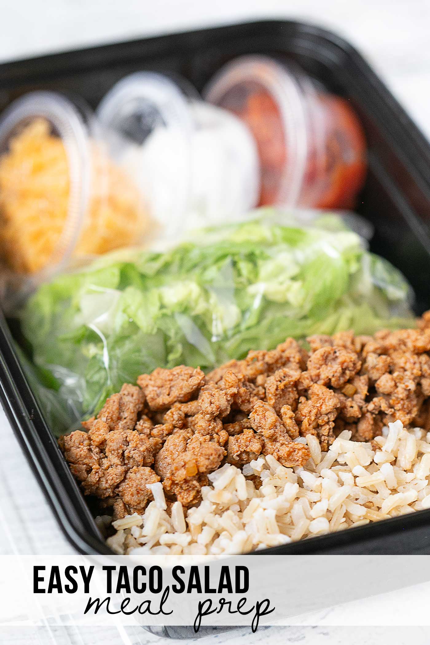 Taco salad meal prep with seasoned ground meat, brown rice, romaine, cheese, sour cream, and salsa with Easy Taco Salad Meal Prep text overlay.