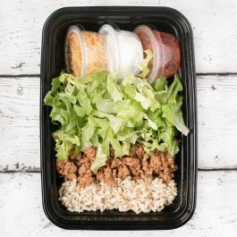 Taco salad meal prep with seasoned ground meat, romaine lettuce, brown rice, cheese, sour cream, and salsa.